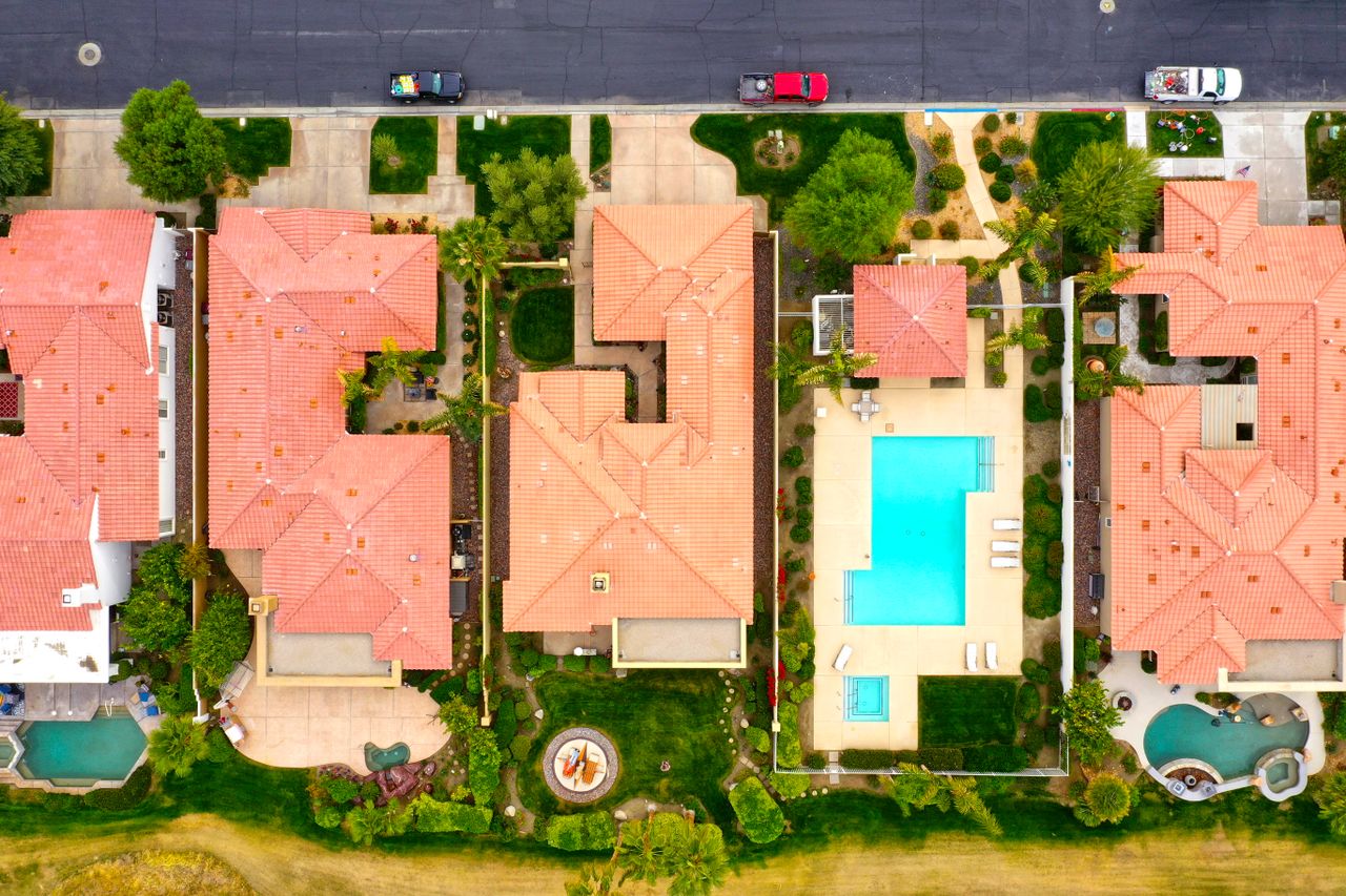 Home Aerial view showing suburban homes with pools in La Quinta, California, highlighting luxury lifestyle.