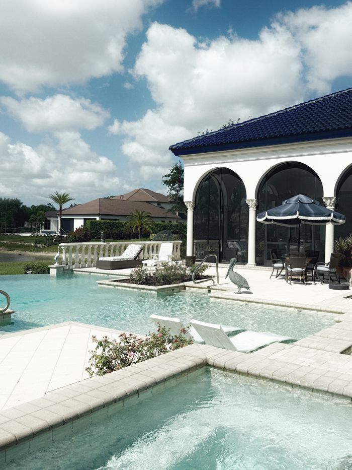 Elegant pool area with luxurious architecture in sunny Florida setting, perfect for relaxation.
